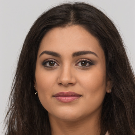 Joyful latino young-adult female with long  brown hair and brown eyes