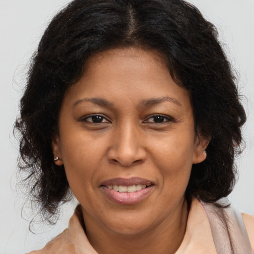 Joyful black adult female with long  brown hair and brown eyes