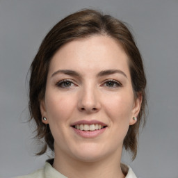 Joyful white young-adult female with medium  brown hair and grey eyes