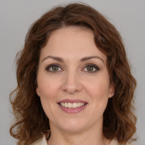 Joyful white young-adult female with medium  brown hair and green eyes