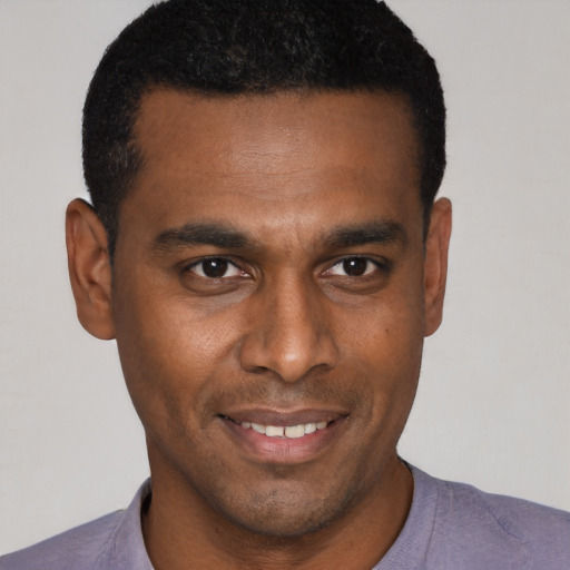 Joyful black young-adult male with short  brown hair and brown eyes