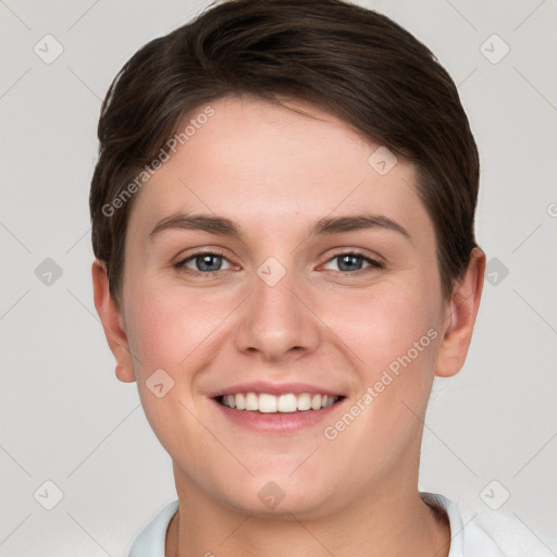 Joyful white young-adult female with short  brown hair and grey eyes