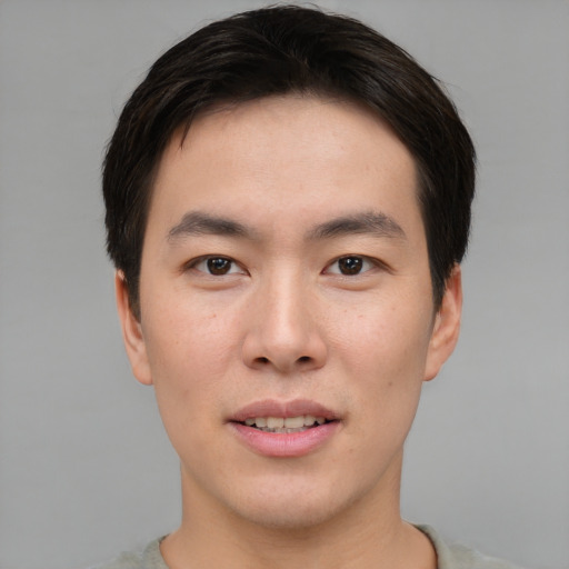 Joyful asian young-adult male with short  brown hair and brown eyes
