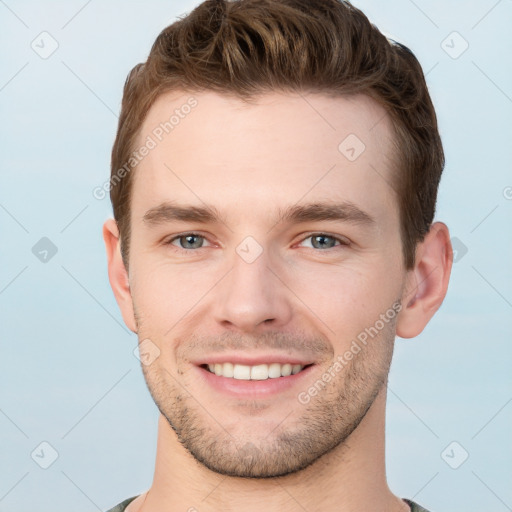 Joyful white young-adult male with short  brown hair and grey eyes