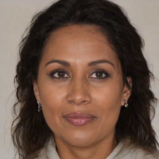Joyful black adult female with long  brown hair and brown eyes