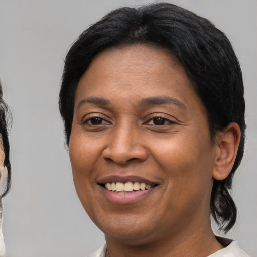 Joyful latino young-adult female with medium  brown hair and brown eyes