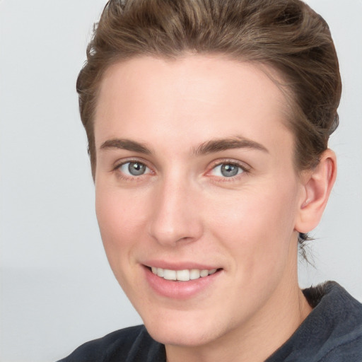 Joyful white young-adult female with short  brown hair and grey eyes