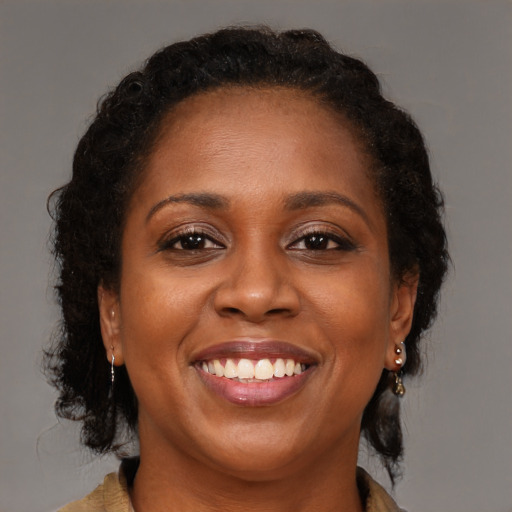 Joyful black adult female with long  brown hair and brown eyes
