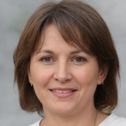 Joyful white adult female with medium  brown hair and grey eyes