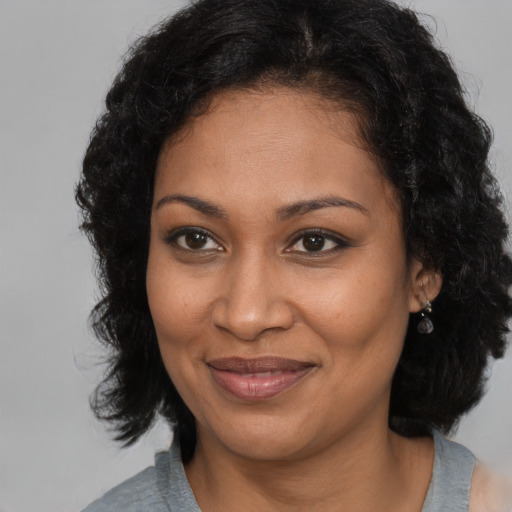Joyful black adult female with medium  brown hair and brown eyes