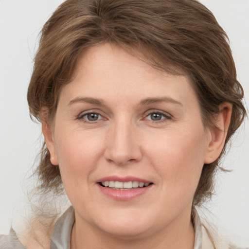 Joyful white young-adult female with medium  brown hair and grey eyes