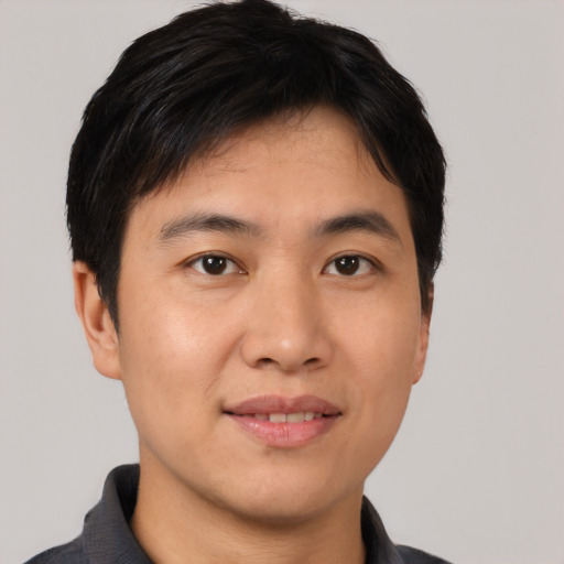 Joyful asian young-adult male with short  black hair and brown eyes