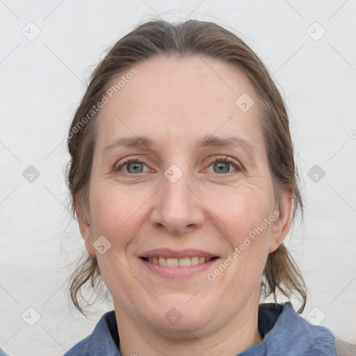 Joyful white adult female with medium  brown hair and blue eyes