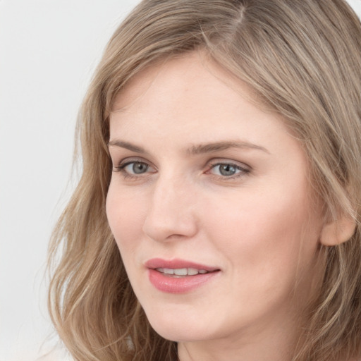 Joyful white young-adult female with long  brown hair and grey eyes