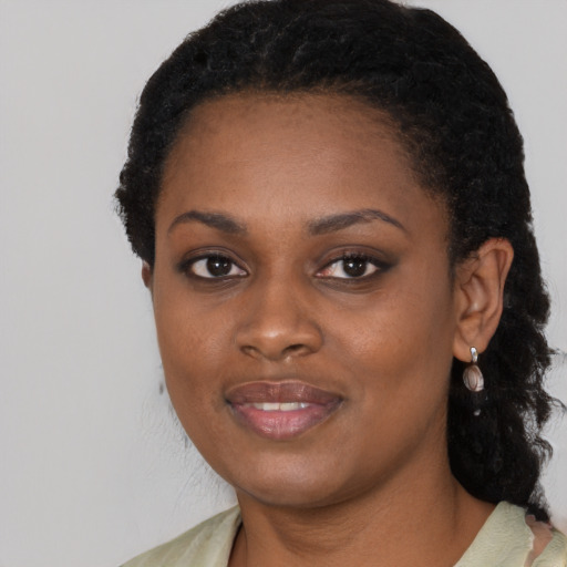 Joyful black young-adult female with short  black hair and brown eyes