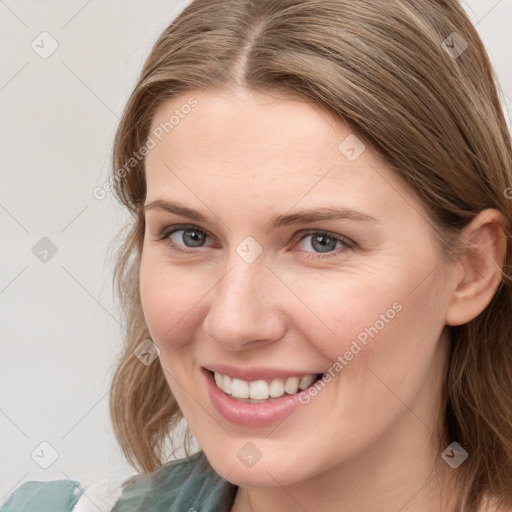 Joyful white young-adult female with long  brown hair and blue eyes