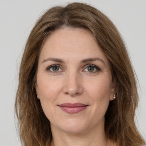 Joyful white adult female with long  brown hair and grey eyes