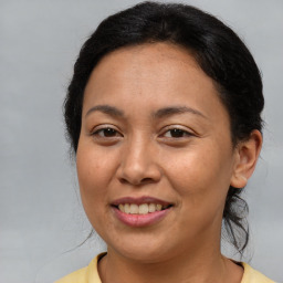 Joyful latino young-adult female with medium  brown hair and brown eyes