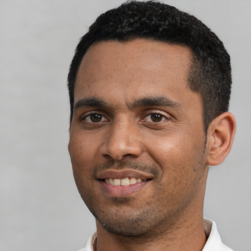 Joyful black young-adult male with short  black hair and brown eyes