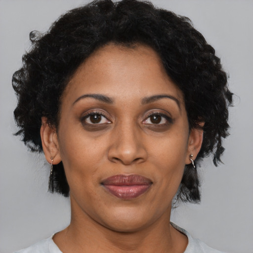 Joyful black adult female with short  black hair and brown eyes