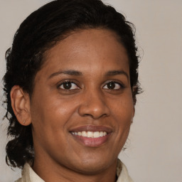 Joyful black young-adult female with medium  brown hair and brown eyes