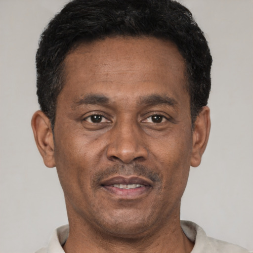 Joyful black adult male with short  black hair and brown eyes