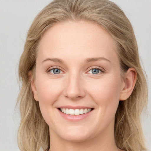 Joyful white young-adult female with long  brown hair and blue eyes