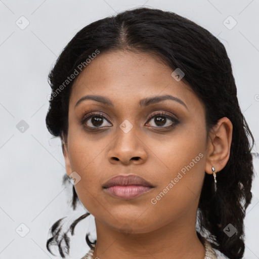 Joyful black young-adult female with long  black hair and brown eyes