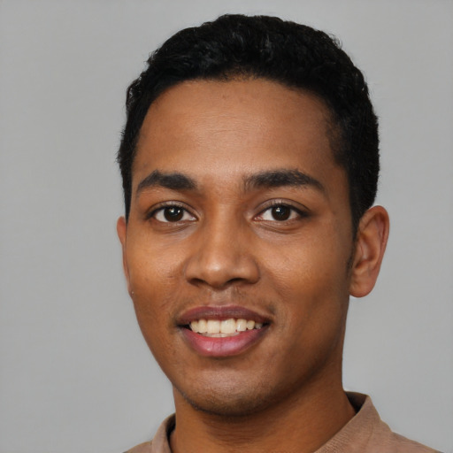 Joyful black young-adult male with short  black hair and brown eyes