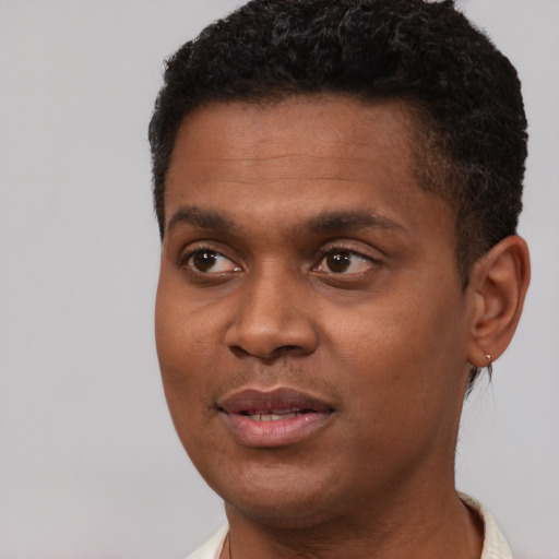 Joyful black young-adult male with short  black hair and brown eyes