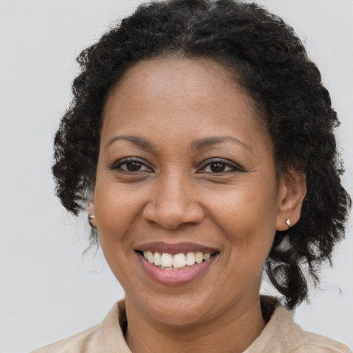Joyful black adult female with medium  brown hair and brown eyes