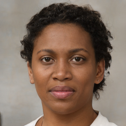 Joyful black young-adult female with short  brown hair and brown eyes