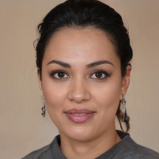 Joyful latino young-adult female with medium  brown hair and brown eyes