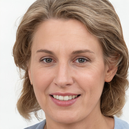 Joyful white adult female with medium  brown hair and blue eyes