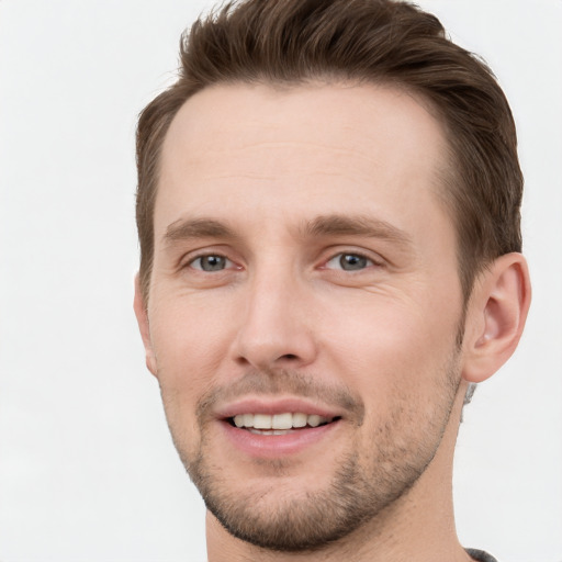 Joyful white young-adult male with short  brown hair and grey eyes