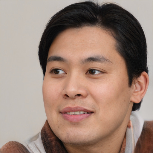 Joyful asian young-adult male with short  brown hair and brown eyes