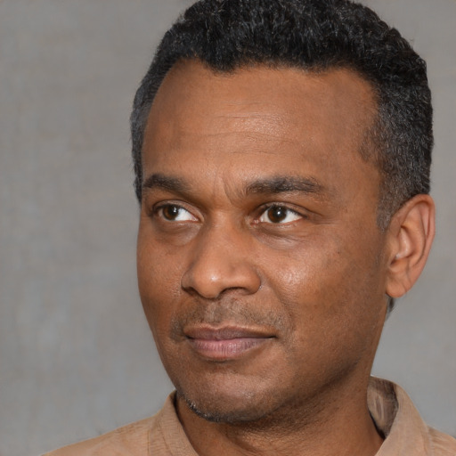 Joyful black adult male with short  black hair and brown eyes