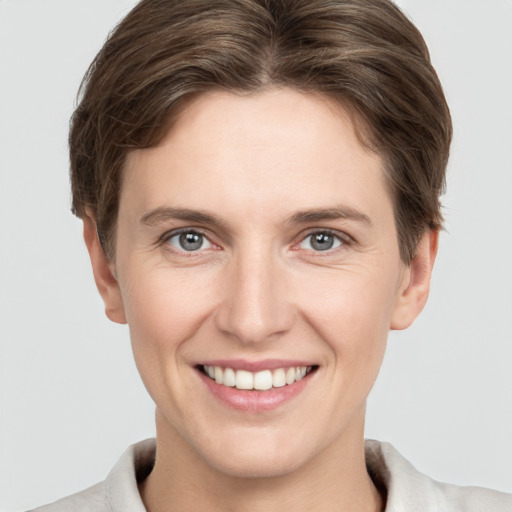 Joyful white young-adult female with short  brown hair and grey eyes