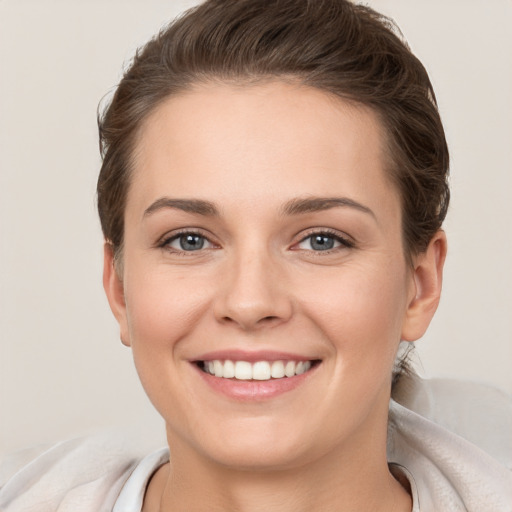 Joyful white young-adult female with short  brown hair and grey eyes