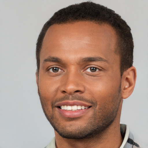 Joyful black young-adult male with short  brown hair and brown eyes