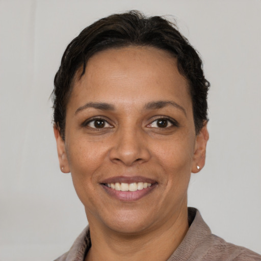 Joyful latino young-adult female with short  brown hair and brown eyes