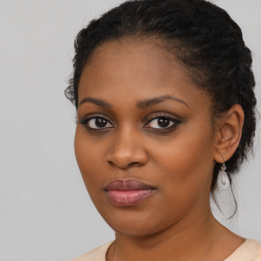 Joyful black young-adult female with long  brown hair and brown eyes