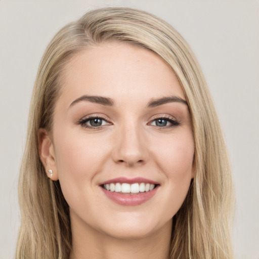 Joyful white young-adult female with long  brown hair and blue eyes