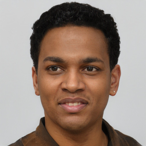 Joyful black young-adult male with short  black hair and brown eyes
