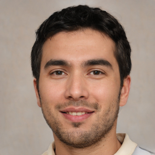 Joyful white young-adult male with short  black hair and brown eyes