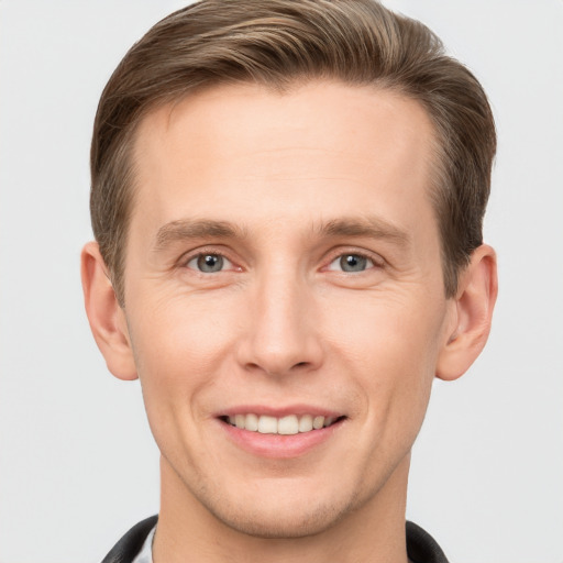 Joyful white young-adult male with short  brown hair and grey eyes