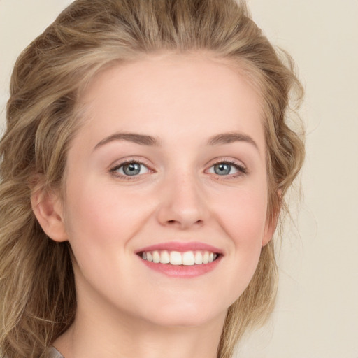 Joyful white young-adult female with long  brown hair and blue eyes