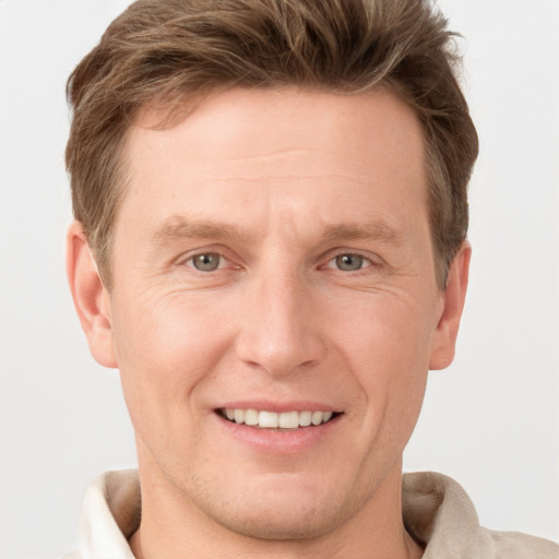 Joyful white adult male with short  brown hair and grey eyes