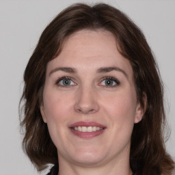 Joyful white adult female with medium  brown hair and grey eyes