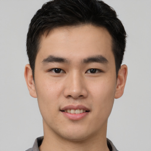 Joyful asian young-adult male with short  brown hair and brown eyes